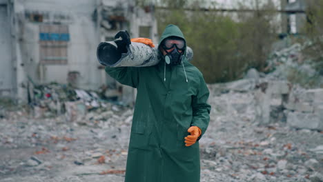 worker in protective suit in radiation zone. builder in safety uniform and gas mask is carrying pipe in destroyed place. chemical attack.