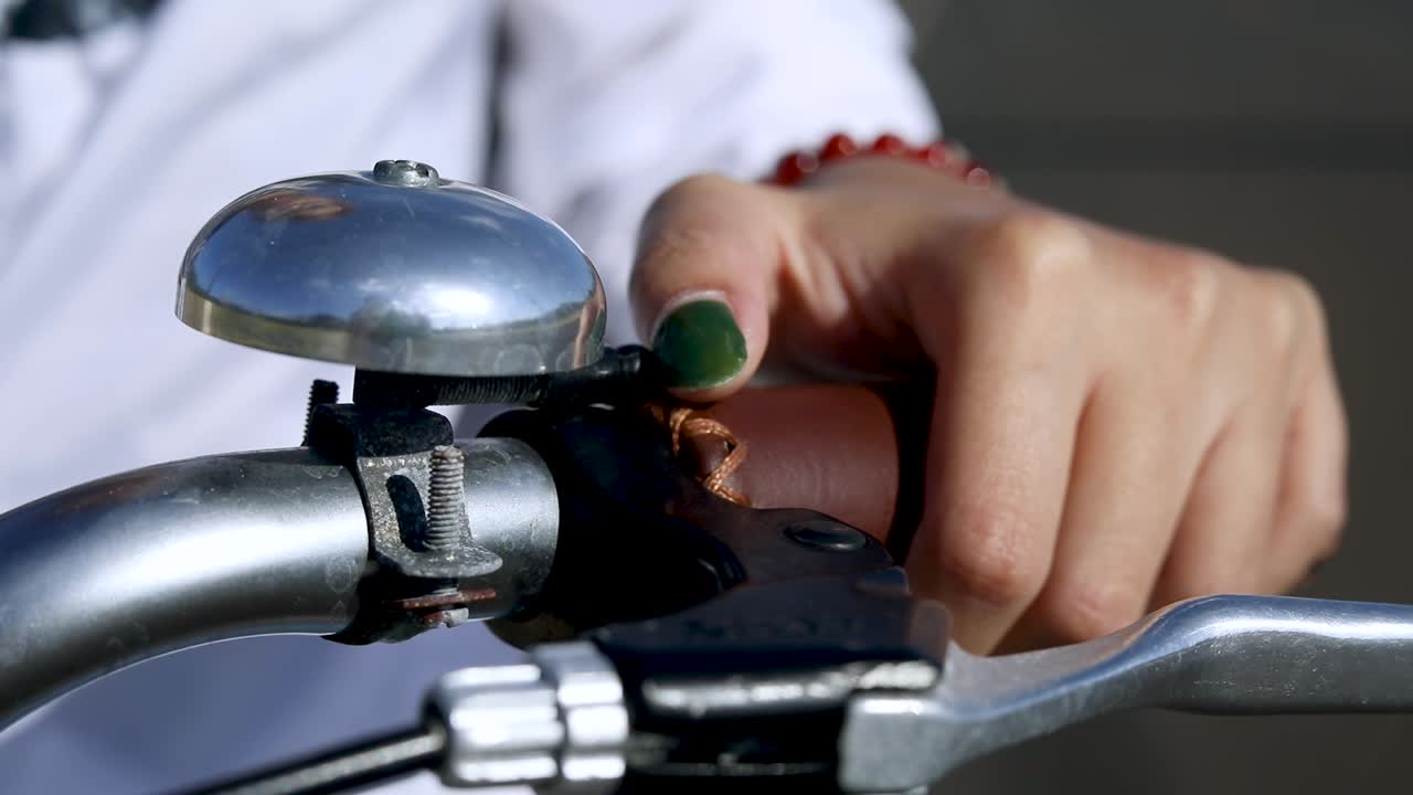 Person Ringing Bicycle Bell on Bike Handlebars, Closeup