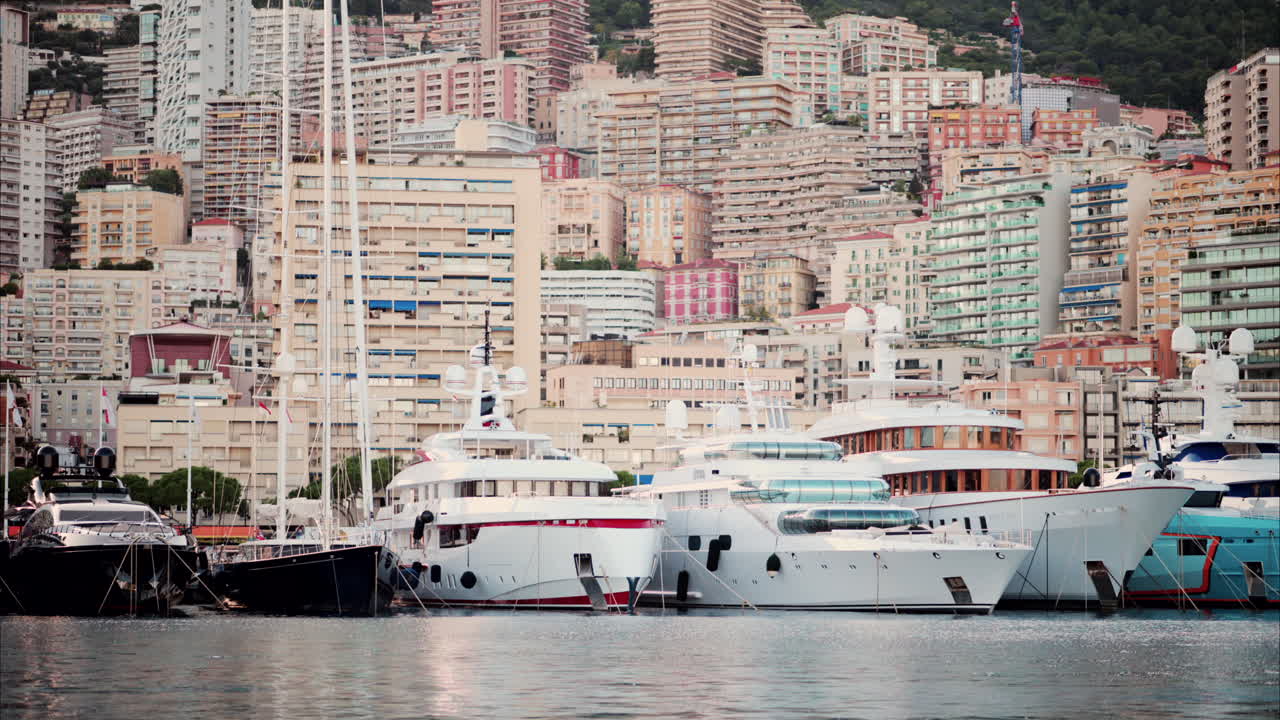 View of boats docked in the Monaco Marina with the skyline of the city on the background