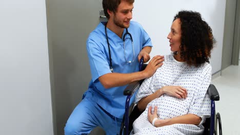 doctor comforting pregnant woman in corridor