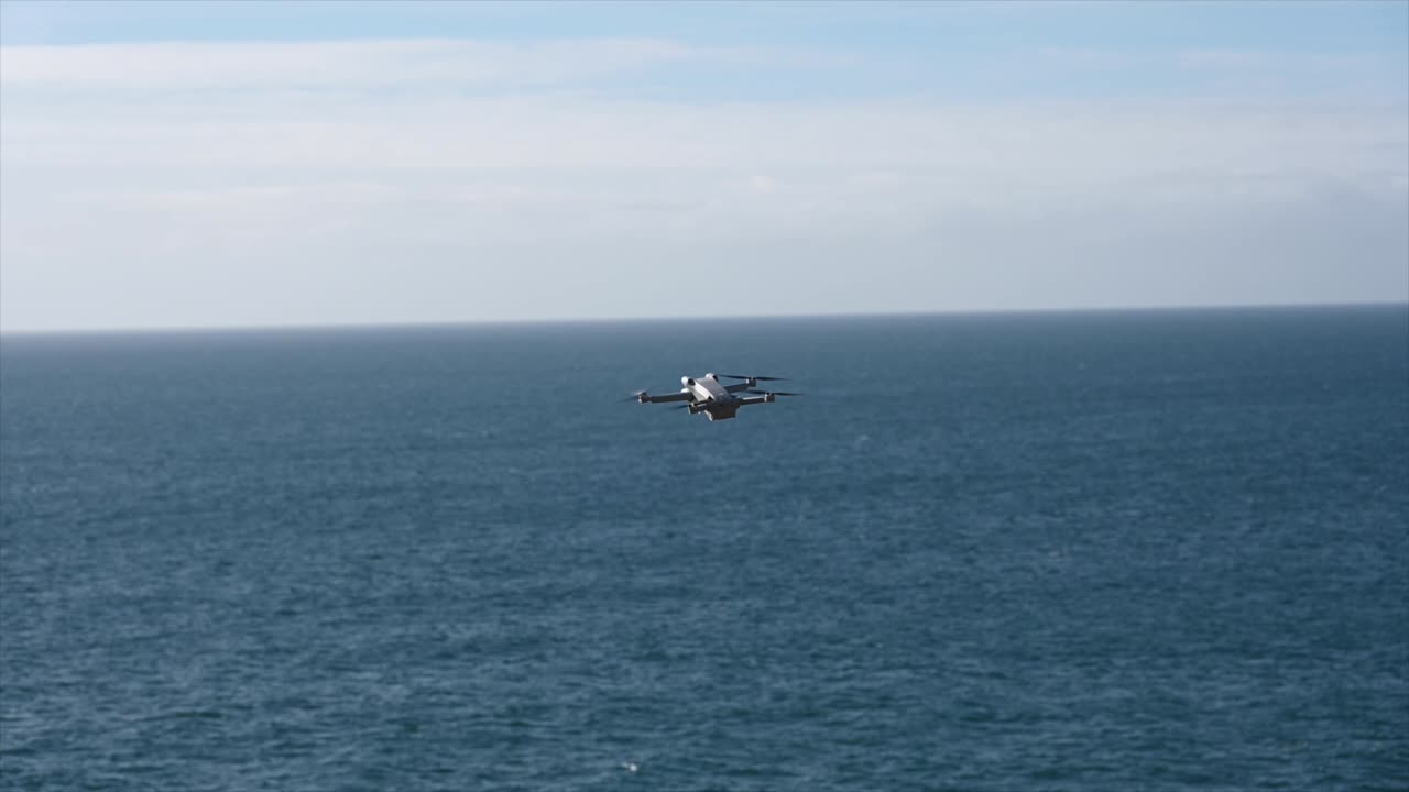 프로펠러가 있는 영화 제작 장비인 영국 채널 위의 무인 항공기가 정지 상태로 날아갑니다.