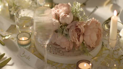 close up of bouquet on table set for meal at wedding reception with place card for bride 2