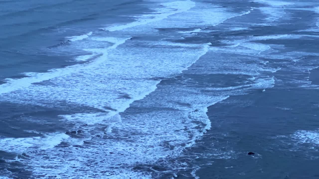 Handheld telephoto tilting up shot of strong ocean surf at Crescent Beach in Crescent City, California. 4K