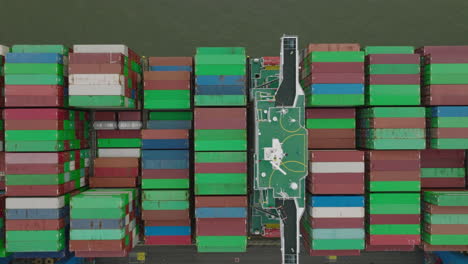 Top-down-shot-of-colourful-containers-loading-on-big-cargo-boat.-Intermodal-transport-and-global-logistics.-Hamburg,-Germany