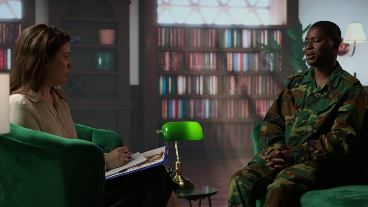 un soldado afroamericano en uniforme de camuflaje se sienta en terapia