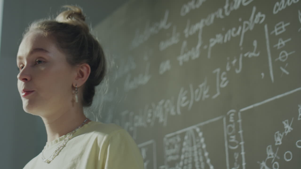 Young Woman Standing by a Chalkboard with Formulas