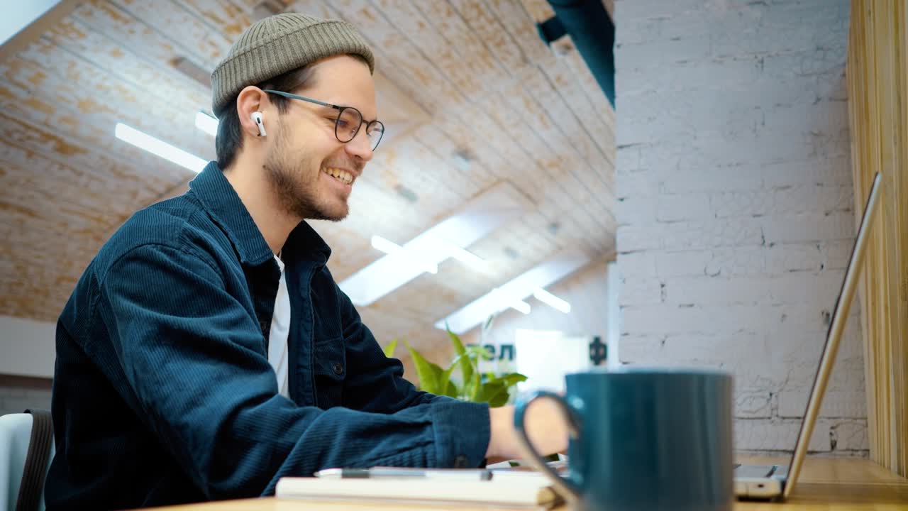 l'uomo ha completato con successo il lavoro sul computer ed è felice, sorridendo e facendo un gesto con la mano.
