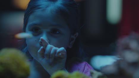 cute little girl in aquarium looking at fish curious child watching colorful sea life swimming in tank learning about marine animals in underwater ecosystem inquisitive kid at oceanarium