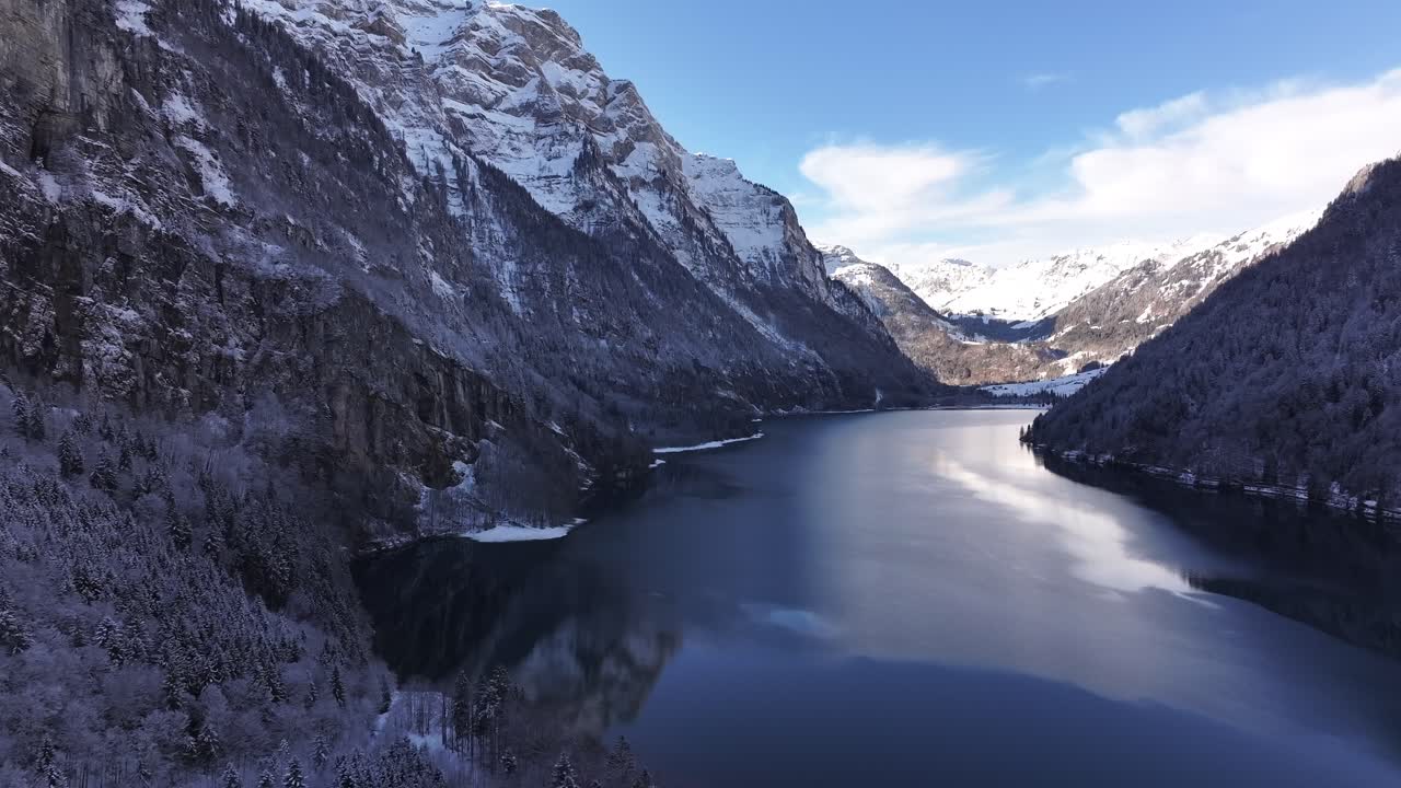 Snowy Klöntalersee surrounded by majestic mountains in Glarus, Switzerland