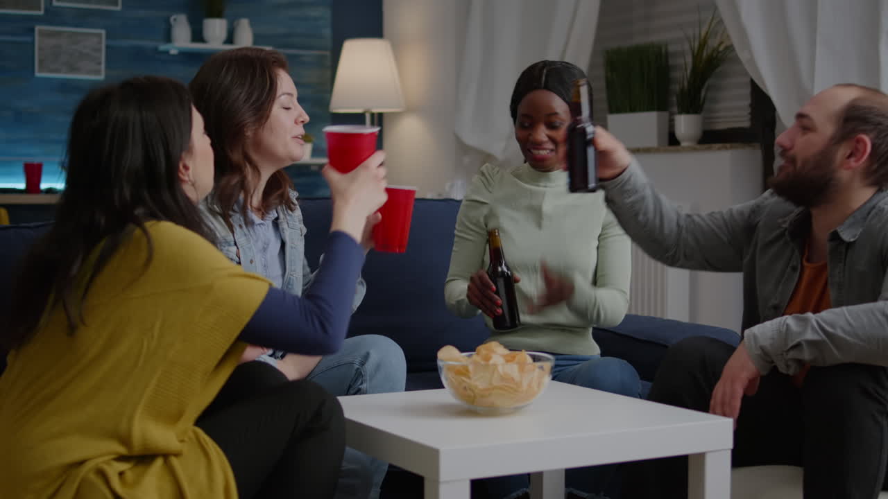 Multi-ethnic friends spending time together, drinking beer during nightlife party