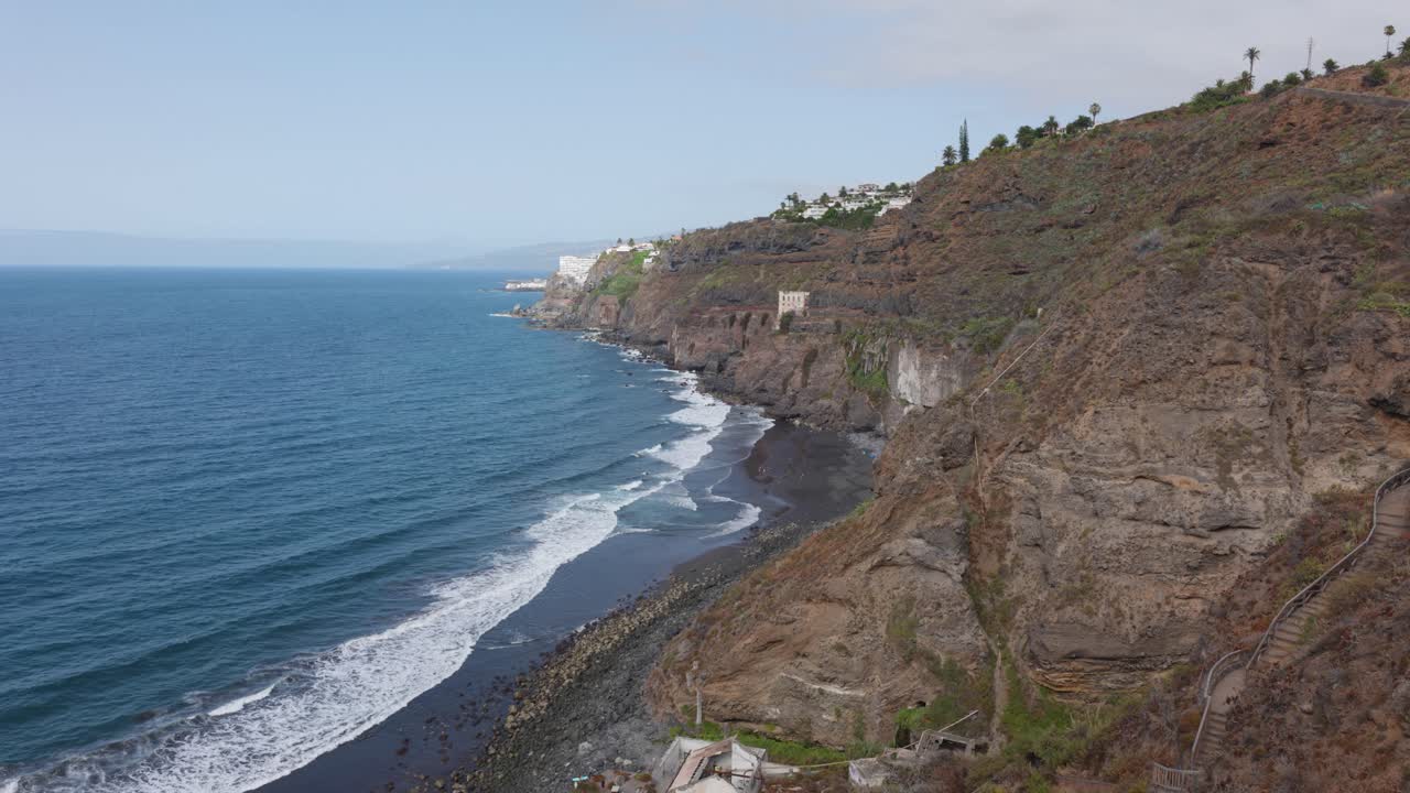 Cliffs and a black sand beach next to the ocean in Tenerife, Canary Islands, Spain.