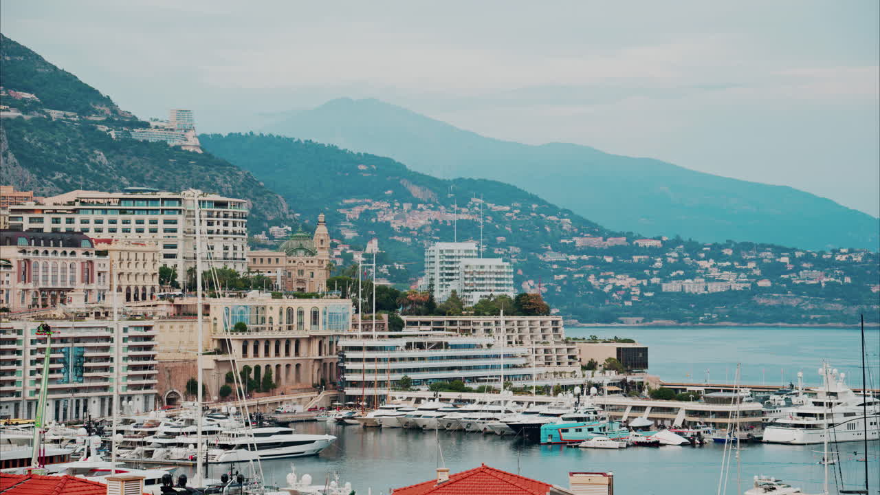 Vista aerea delle barche ormeggiate nel porto turistico di Monaco, con lo skyline della città sullo sfondo