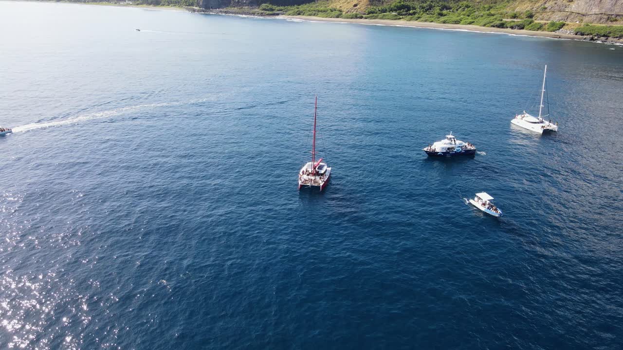 imágenes de drones de un catamarán con personas y varios barcos cerca de la isla de la reunión