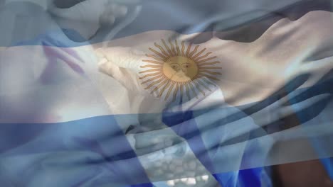 animación de la bandera de argentina sobre diversos cirujanos con máscaras faciales.