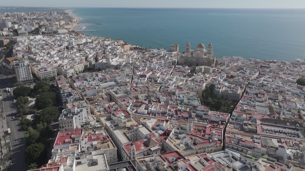 Ripresa aerea cinematografica con drone sopra i tetti della città vecchia di Cadice e la Cattedrale di Cadice con vista sull'Oceano Atlantico, Andalusia, Spagna. Luminoso e soleggiato, primo pomeriggio di fine estate