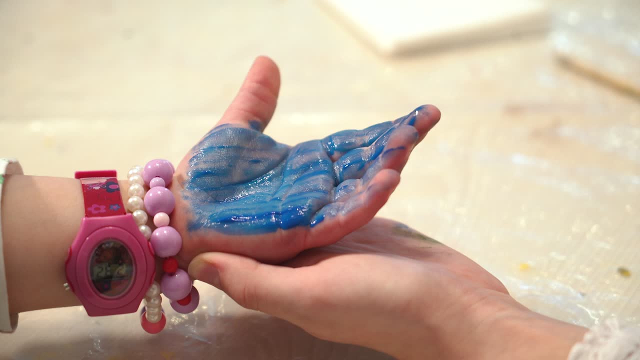 Child hand painted in colorful paint. Early childhood education. Little painter.