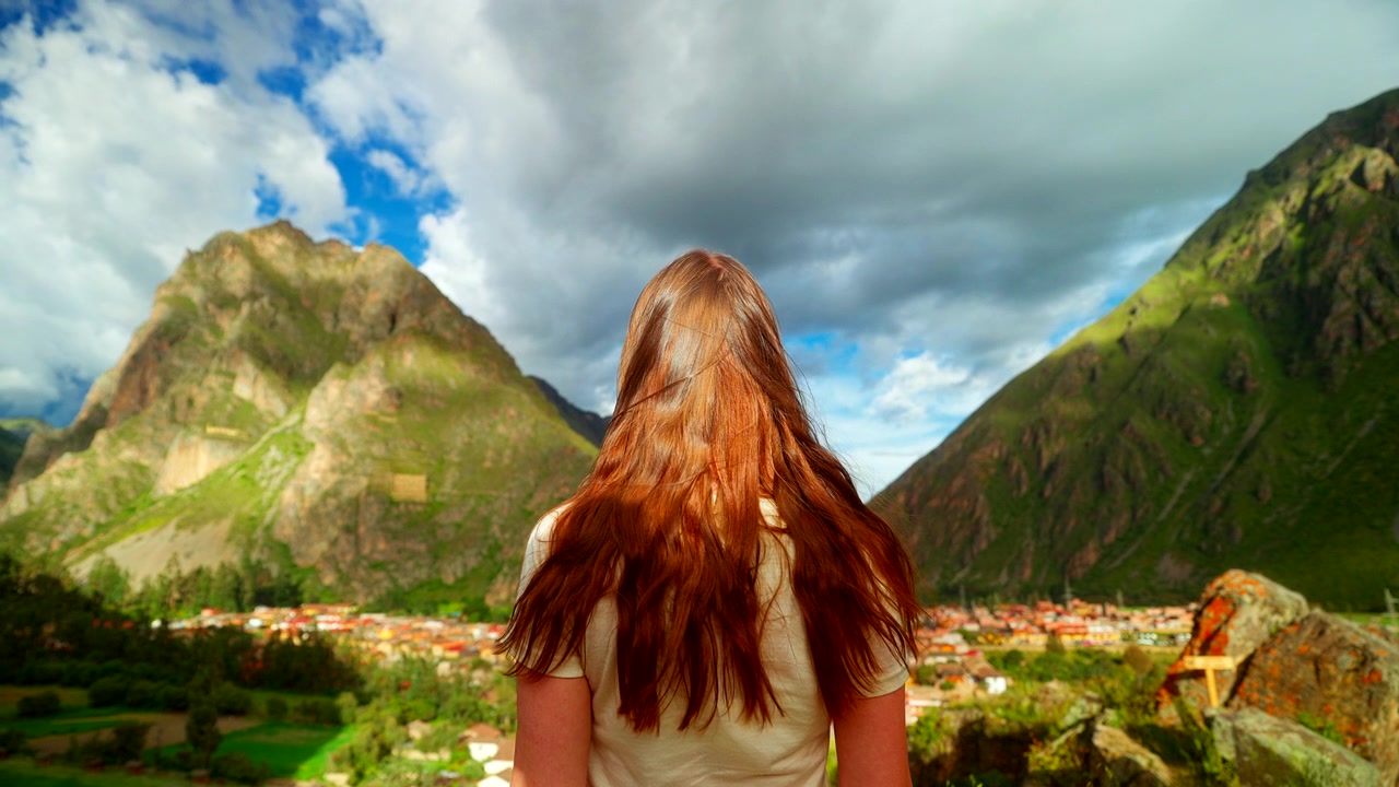 Female traveller at vantage point over Ollantaytambo in Sacred valley. Rear view