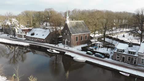 droneshot of snowy dutch landscape with a little church in oud zuilen