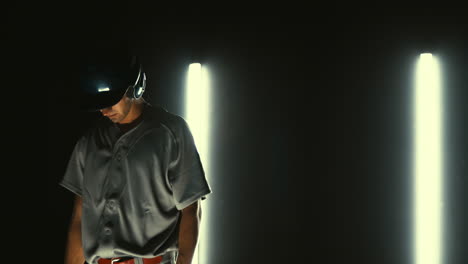 jugador de béisbol profesional caucásico bateando una pelota contra un fondo oscuro. 4k uhd