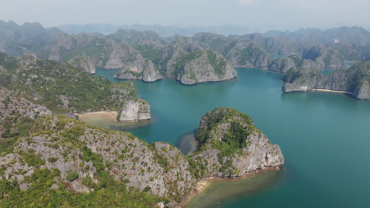 Cat Ba, Vietnam, panoramisk luftfoto af bugt med kalkstensformationer og roligt blågrønt vand, et ideelt tropisk rejsesceneri.