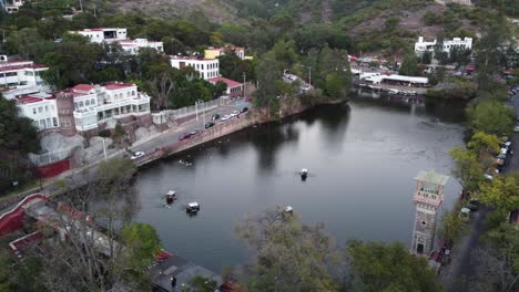 Presa-De-La-Olla-En-Guanajuato,-Con-Cuatro-Botes-De-Remos-Y-Muchos-Patos-Blancos