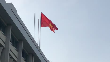 vietnam flag flies in the wind above the presidential palace in ho chi minh city, vietnam