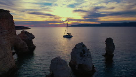 Yate-Anclado-En-El-Mar-Mediterráneo-Junto-A-Cuevas-Y-Rocas-Durante-La-Puesta-De-Sol