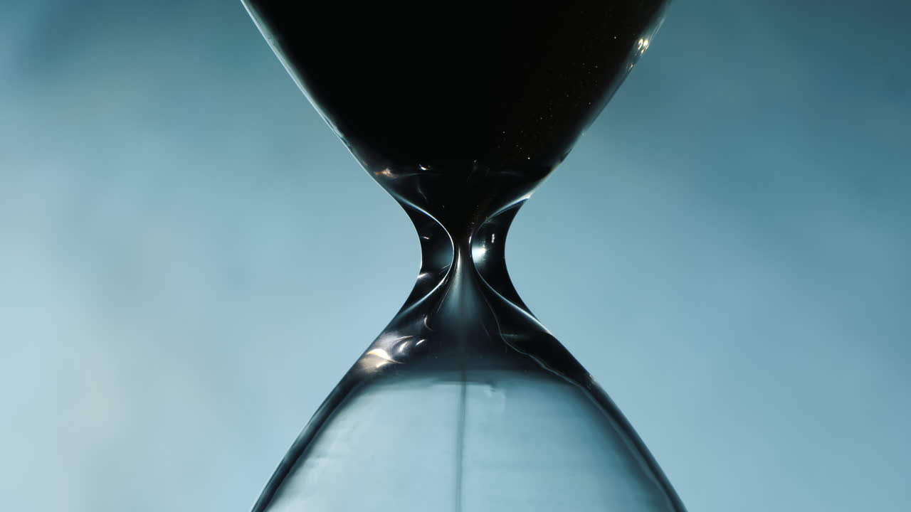 Hourglass against the fog illuminated by the spotlight