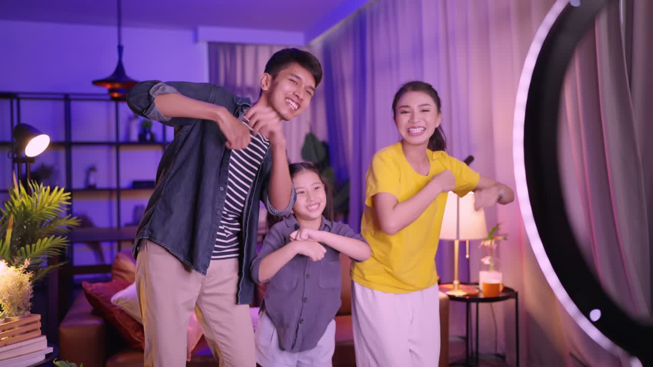 아시안 부모와 딸이 춤을 추고 모바일로 vlog 또는 소셜 미디어를 사용하여 집에서 춤추고 재미있는 운동 활동 일요일 아침 어머니와 딸 소셜 미디어는 춤을 춘다.