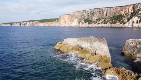 A-strip-of-rock-surrounded-by-a-deep-blue-ocean-and-steep-cliffs