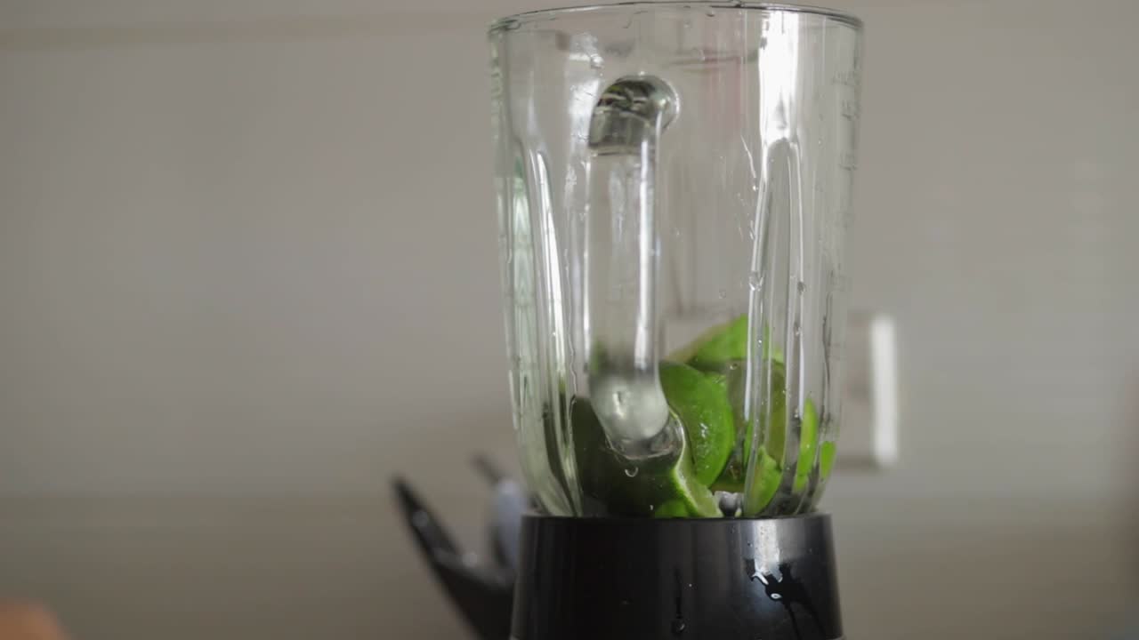 mano de mujer poniendo pedazos de limones dentro de la anteojera