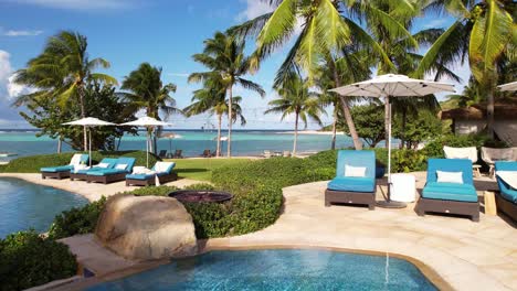 luxury tropical resort on british virgin islands, flying above swimming pools and between palm trees, drone shot