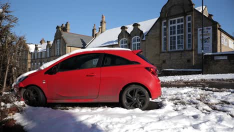 voiture rouge abandonnée après s'être écrasée contre un mur de briques à l'extérieur de l'école, large, statique