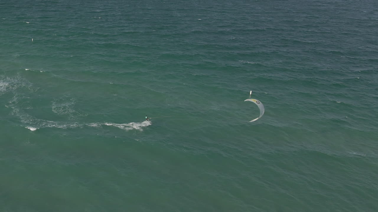 공중: 카이트 서퍼가 카이트를 조종하여 마이애미의 더 깊은 물 속으로 그를 데려갑니다.