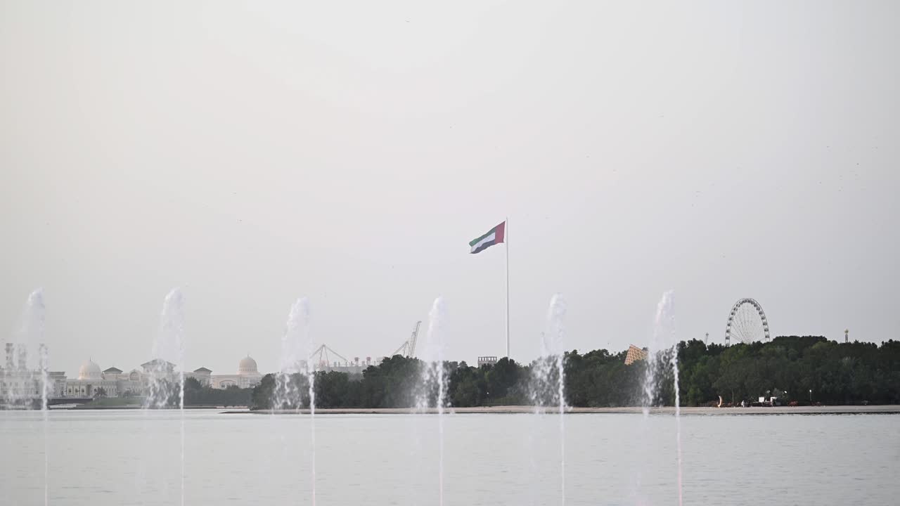 Ampia veduta della bandiera degli Emirati Arabi Uniti che sventola nell'Emirato di Sharjah.