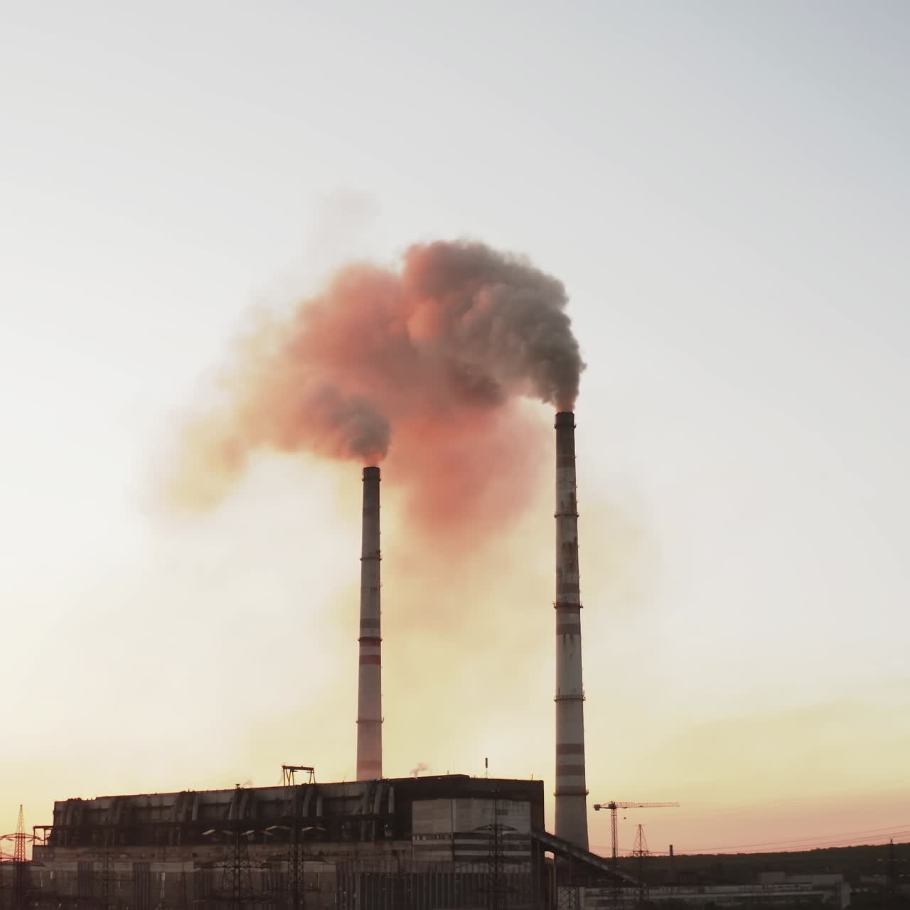 En Static view of the high-voltage tower sky background, factory pipe with smoke over it. Earth pollution and industrialization concept. Selective focus