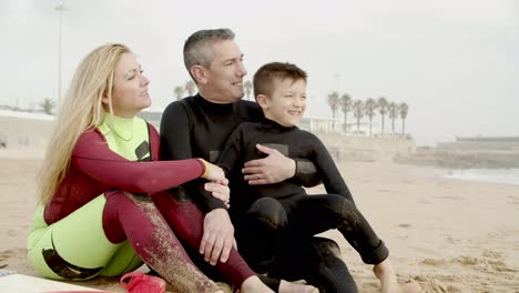 happy family sitting and talking on beach