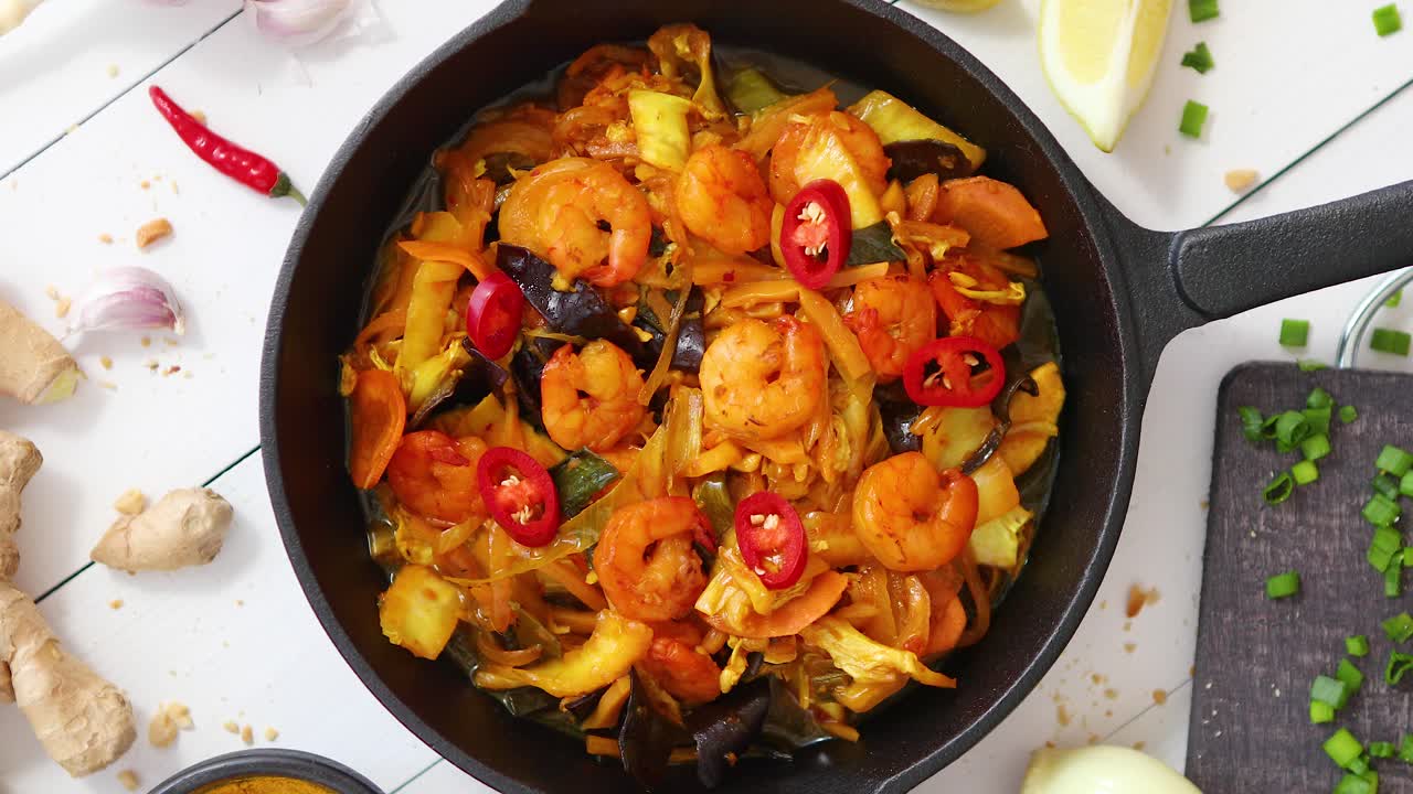 fideos fritos frescos con verduras con camarones servidos en una sartén de hierro negro con varios ingredientes