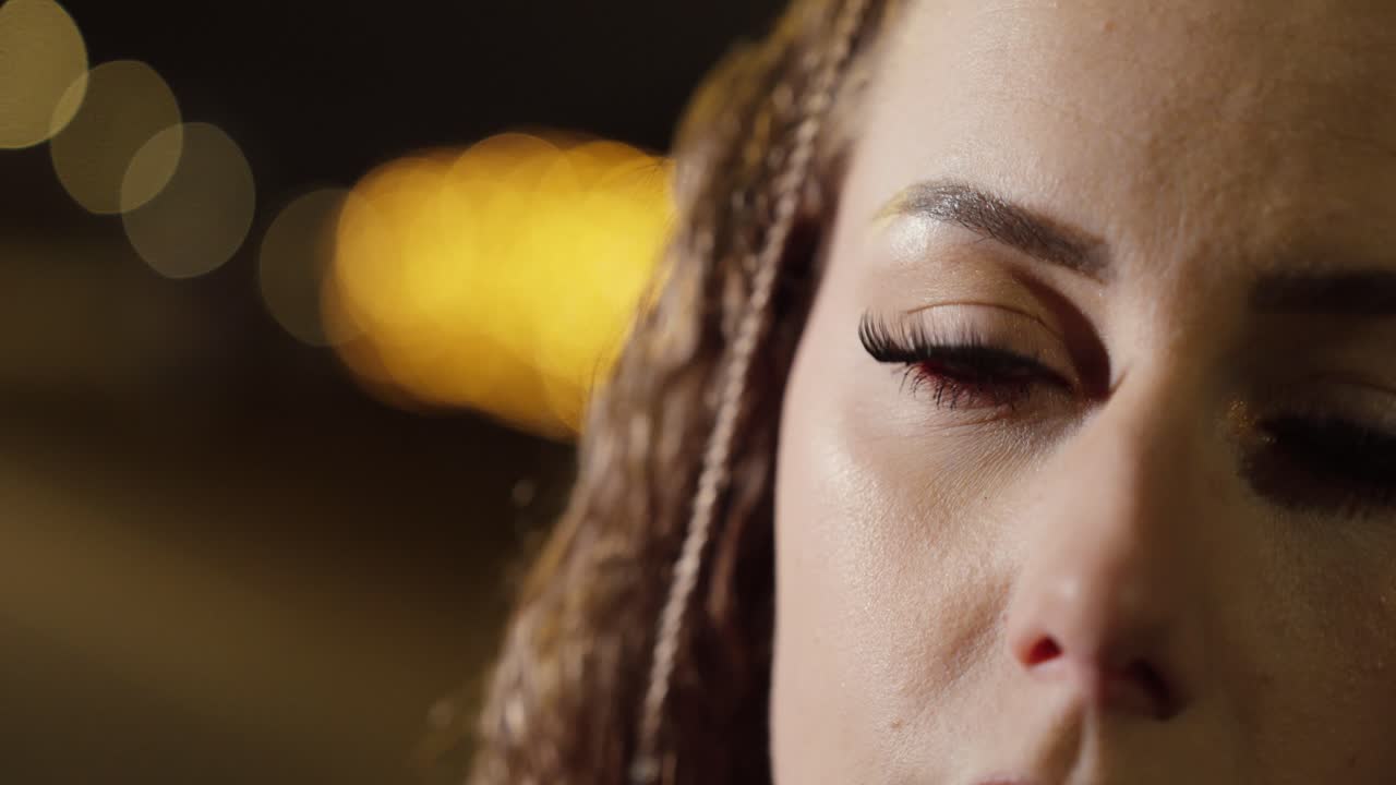 Woman’s blue eyes with bokeh city lights background