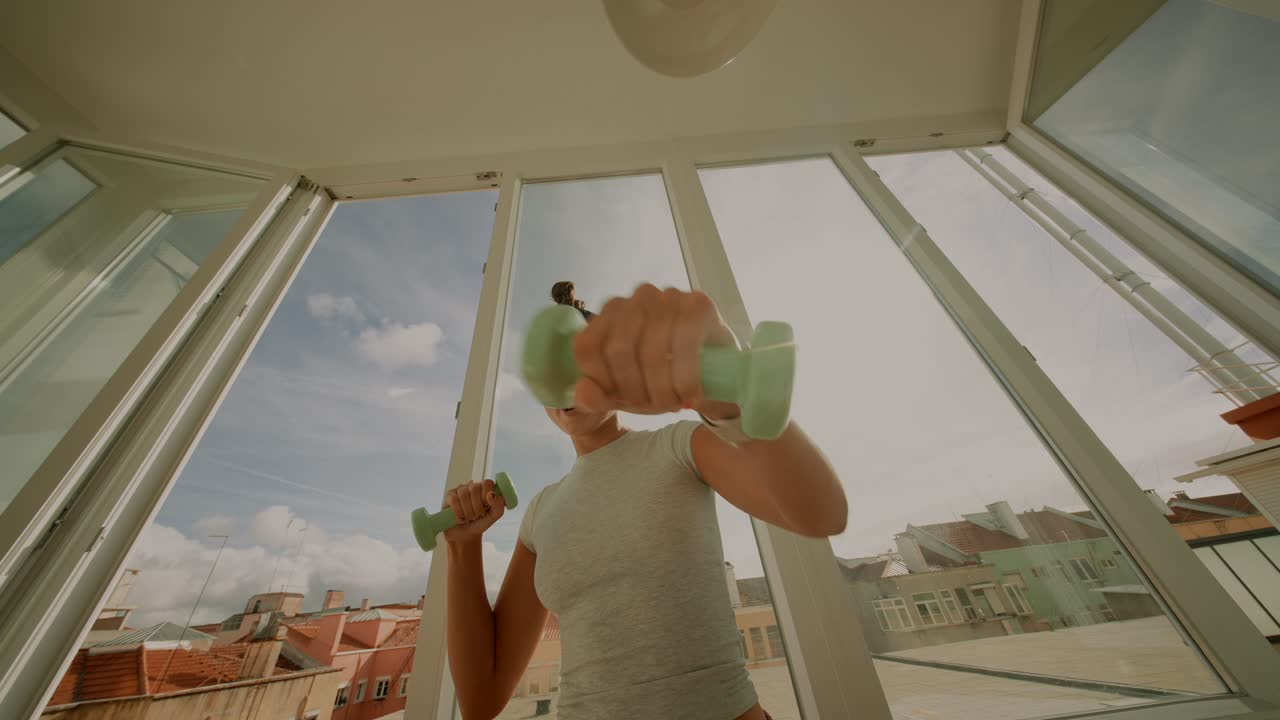 Woman exercising with dumbbells indoors