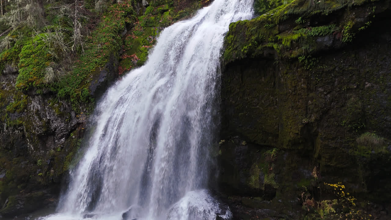 Waterfall in forest in the pacific northwest 4K drone footage ascending from base of waterfall