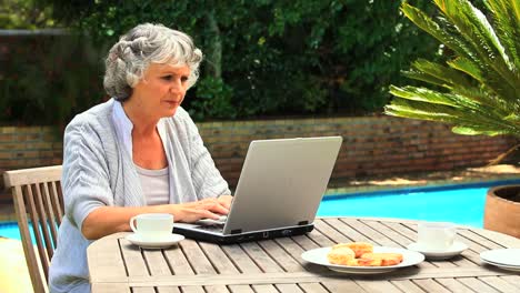 Reife-Frau,-Die-Draußen-An-Ihrem-Laptop-Arbeitet