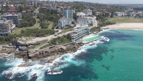 waves crashing on rocky coast of coastal walk - bondi beach and bondi icebergs pool in summer at nsw, australia
