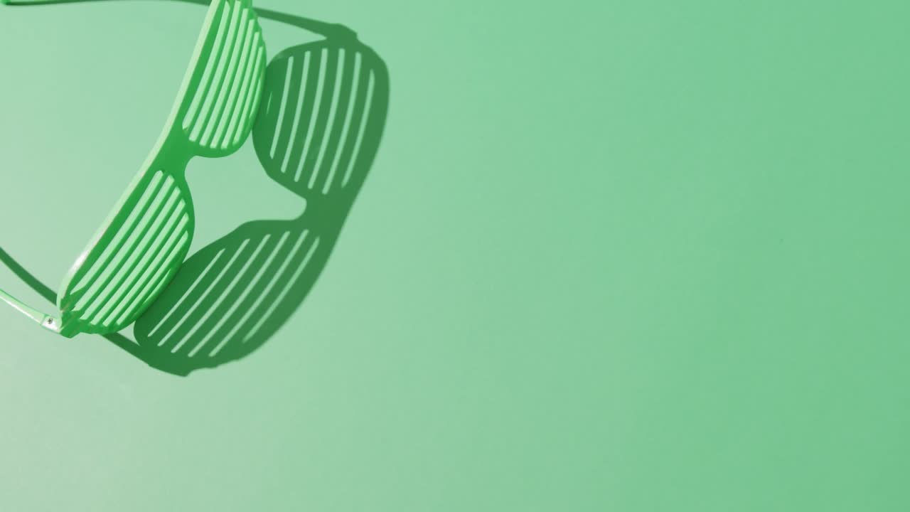 Video of st patrick's green glasses with copy space on green background