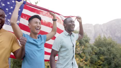 Fröhliche,-Vielfältige-Männliche-Freunde,-Die-Die-Flagge-Der-USA-Halten-Und-Im-Garten-Feiern,-Zeitlupe