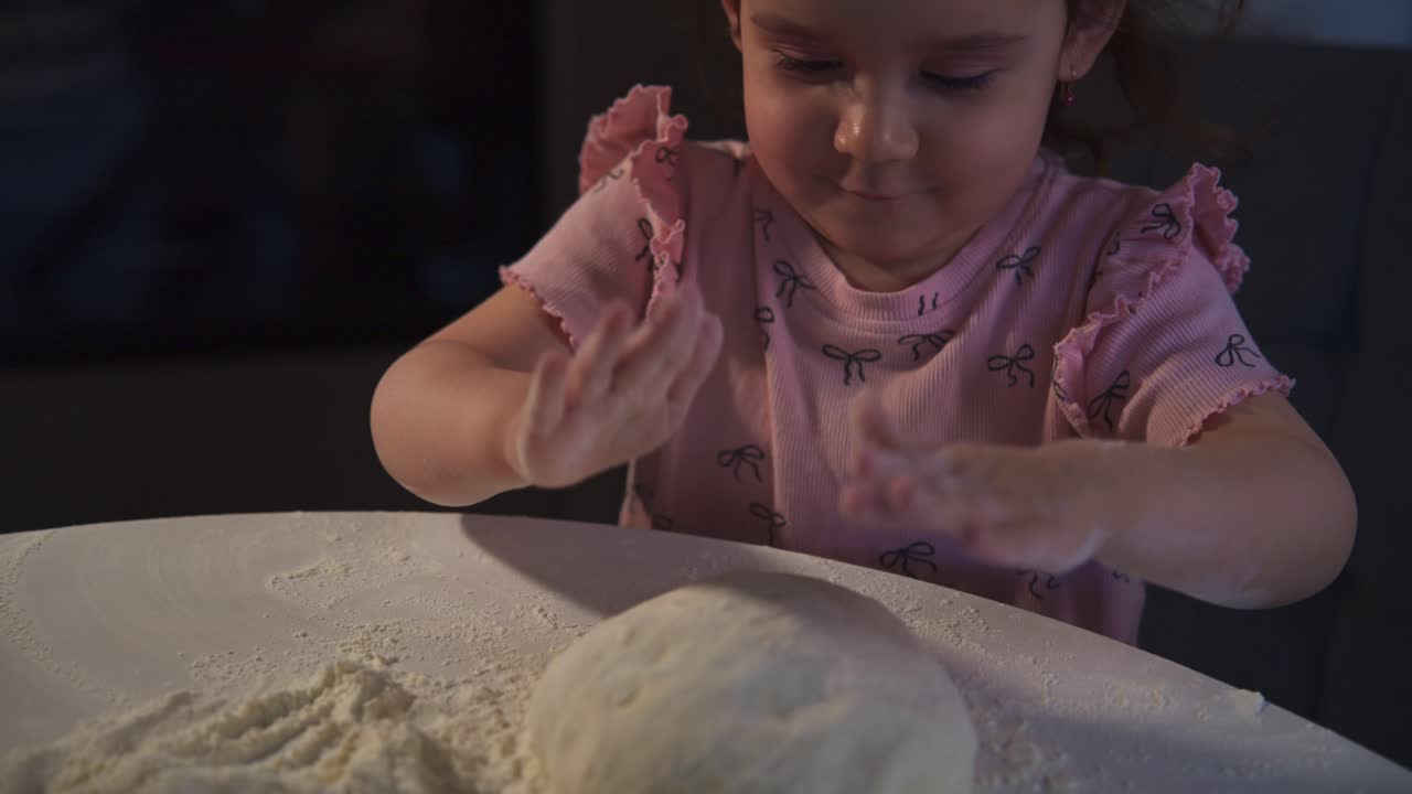 Little Girl Kneading Dough with Flour on a Table