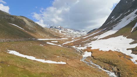 Filmische-Drohnenaufnahme-Eines-Schneebedeckten-Berggipfels-In-Den-Alpen-Im-Sommer