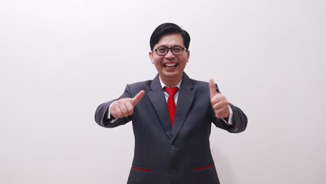 excited asian businessman standing while showing thumbs up