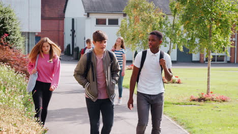 teenage students walking around college campus together