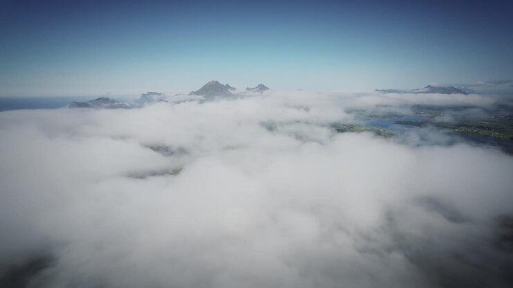 Cinematic FPV drone shot stabilized from lofoten flying over the clouds with mountains in view